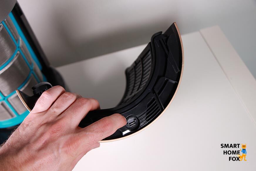 Die Filtereinheit vom Dyson Purifier Cool Formaldehyd Luftreiniger steht auf einem Tisch und der Finger zeigt auf die Taste, die zum Herausnehmen dient.